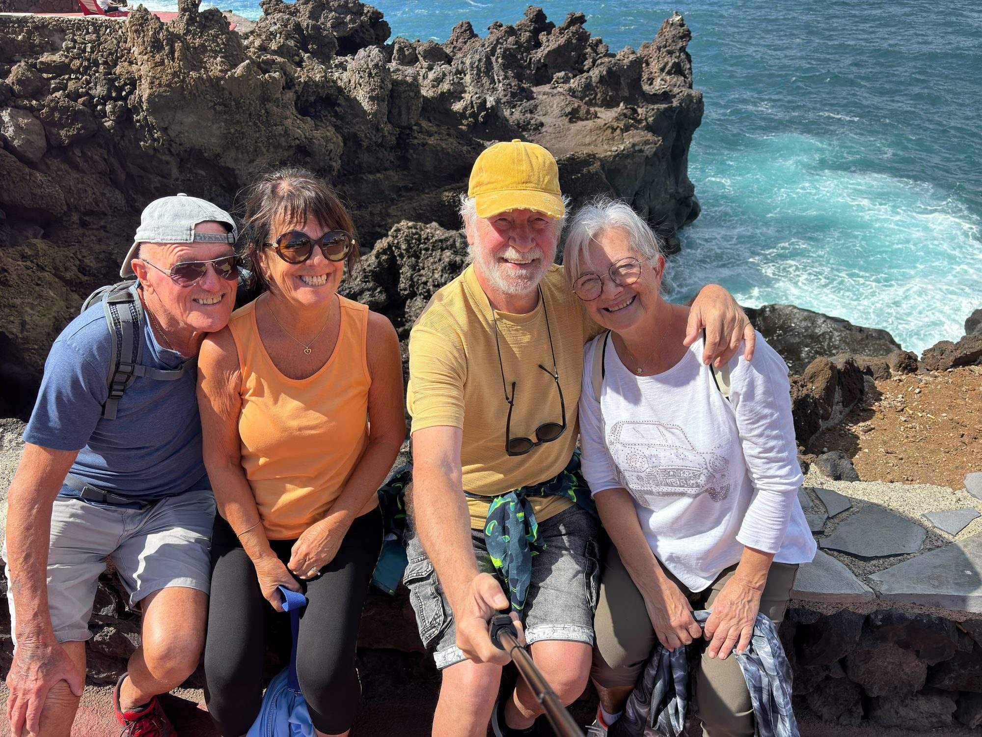 Groupe posant sur des rochers au bord de la mer