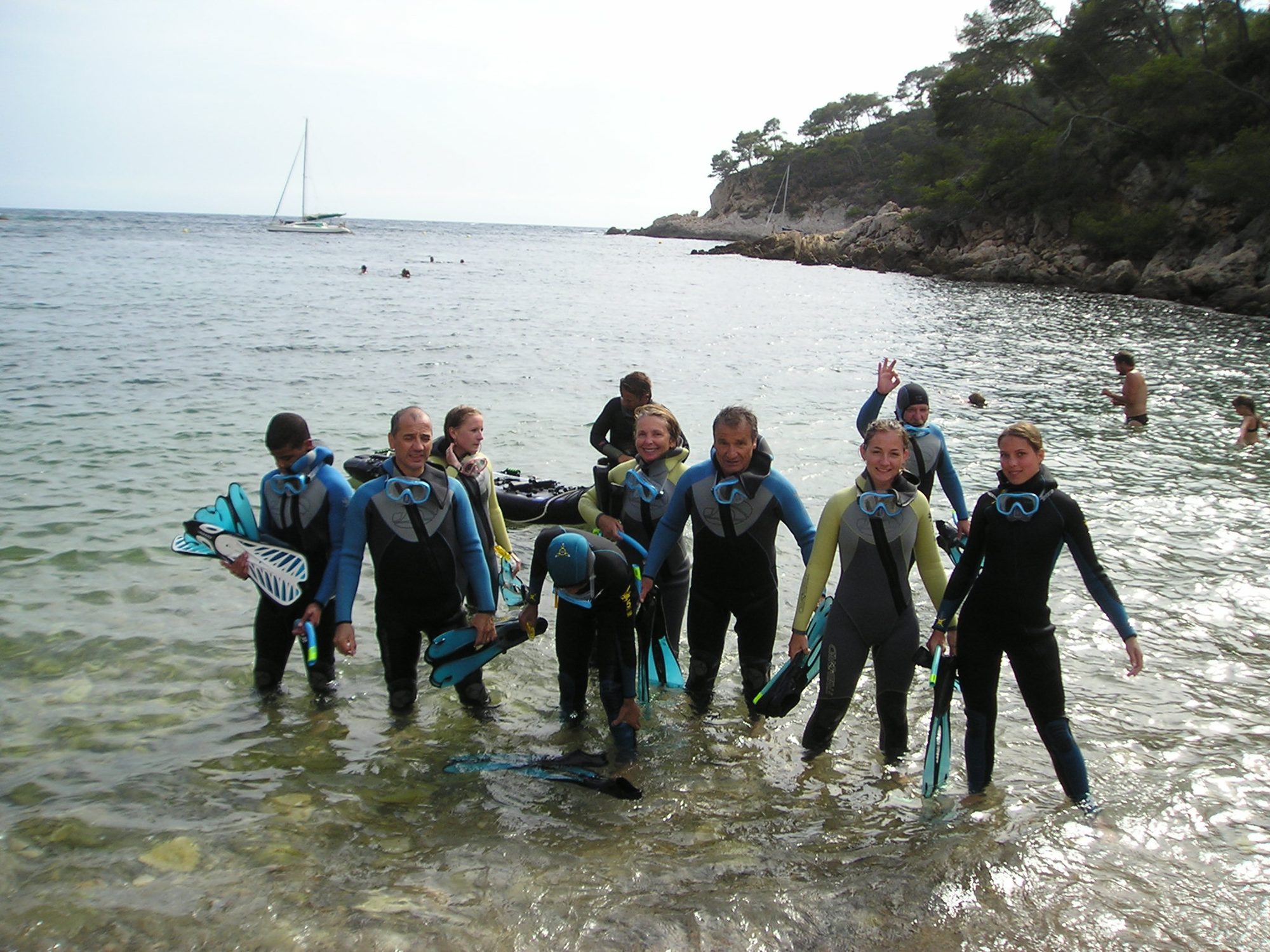 Groupe de plongeurs en combinaison au bord de l'eau
