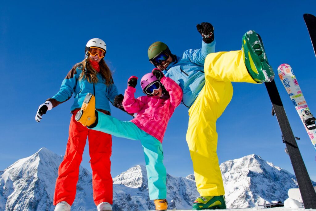 Famille en tenue de ski bras levés