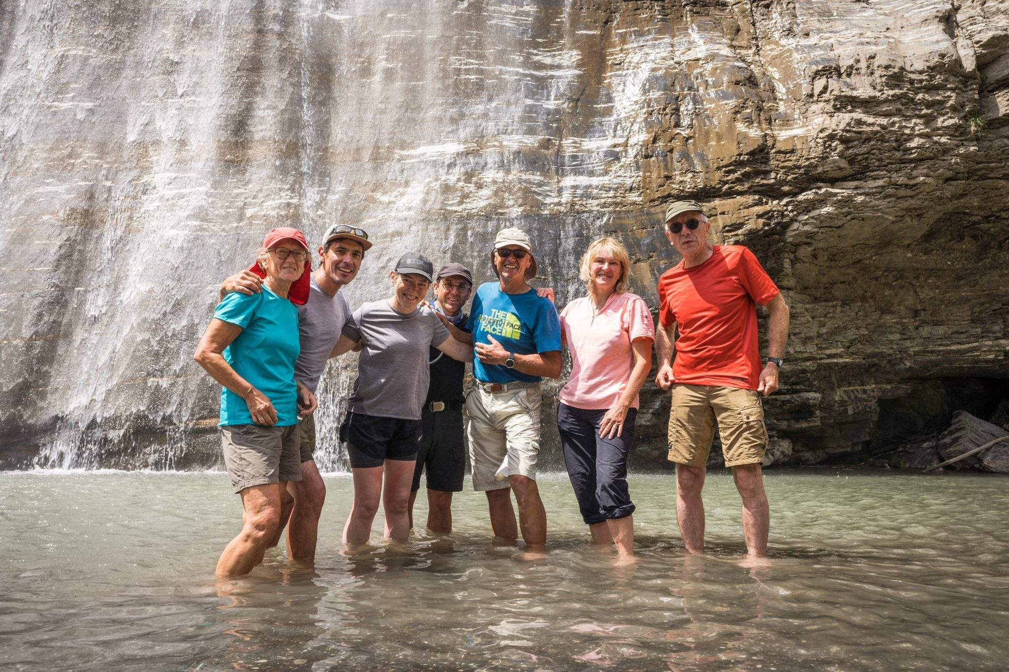 Groupe posant dans une rivière de montagne
