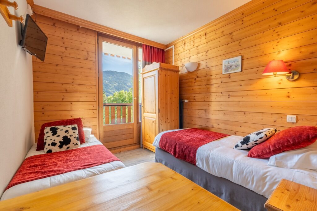 Chambre à deux lits aux rideaux rouges