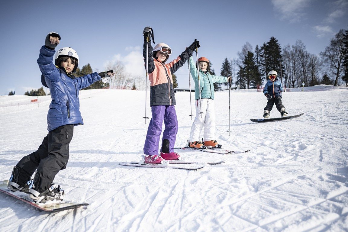 Groupe d'enfants skieurs bras levés