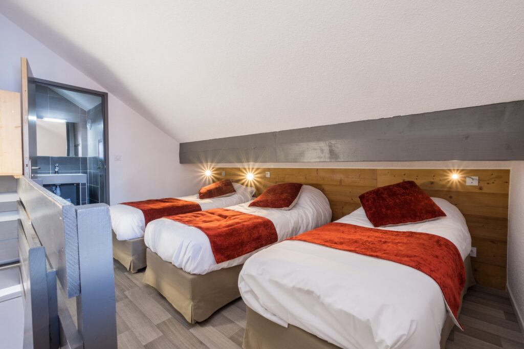 Chambre aux tons sombres et lits jumeaux