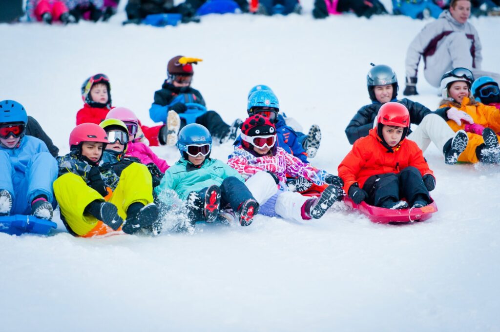 Groupe d'enfants allongés dans la neige après une glissade