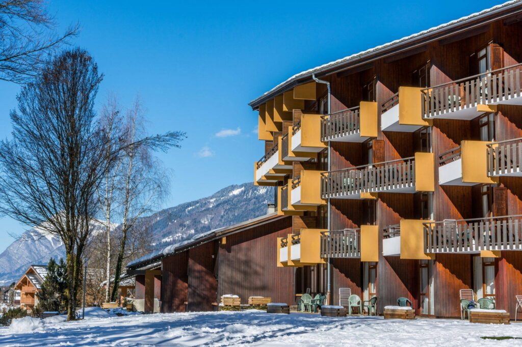 Immeuble à balcons avec sommets enneigés en arrière-plan