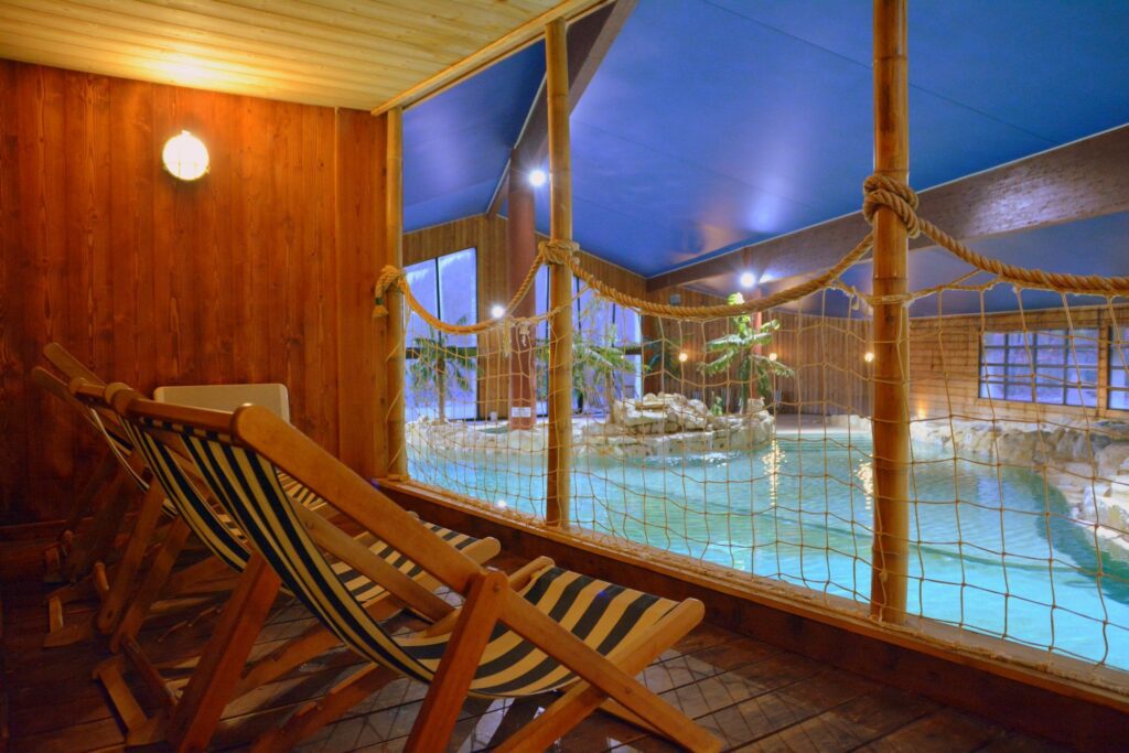 Piscine intérieure avec chaises longues en bois