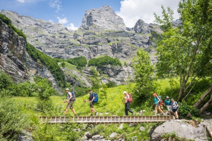 Randonneurs traversant un pont en montagne