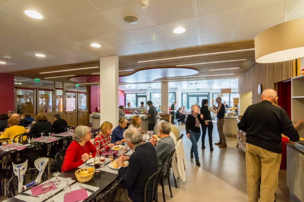 Salle de restaurant animée avec convives à table