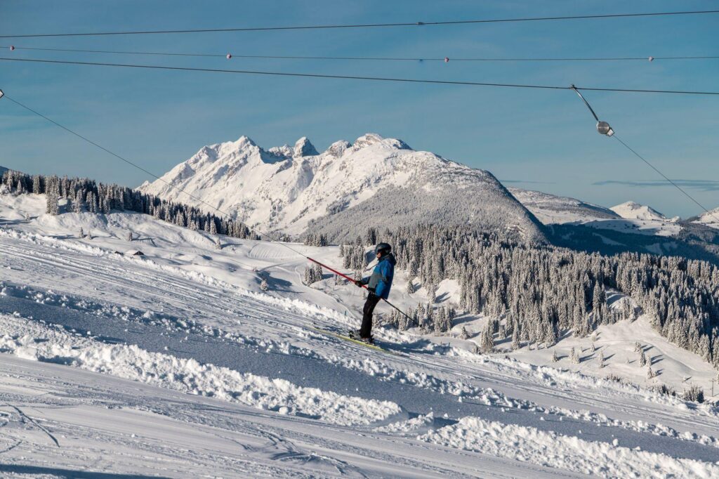 Skieur seul sur une piste face aux sommets
