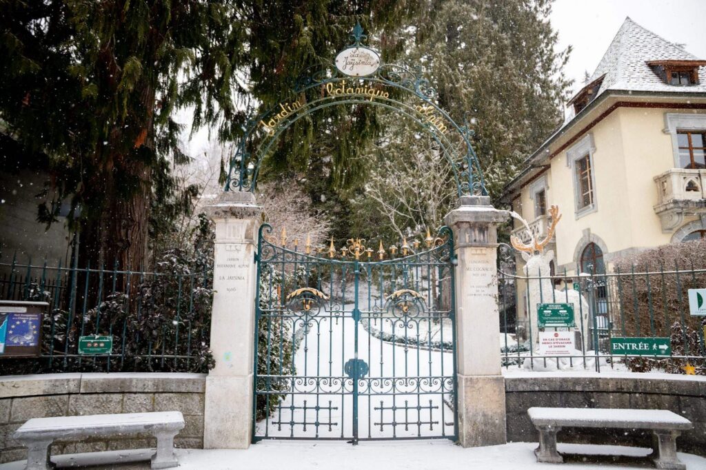 Portail en fer forgé devant un bâtiment enneigé