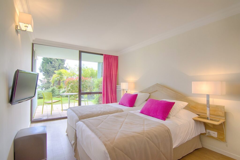 Chambre avec accès terrasse et coussins roses